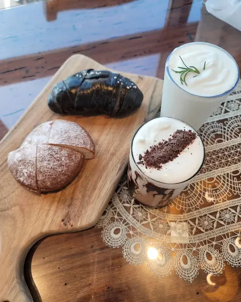 Bir fincan kahve ve ahşap masada bir pasta.