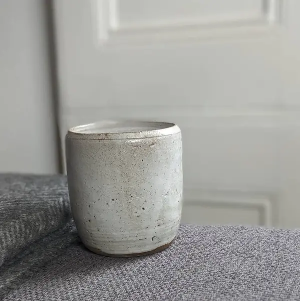 Ahşap bir masada boş bir seramik kabın dikey görüntüsü.