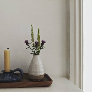 Vazo çiçek ve mumla dolu bir masa.