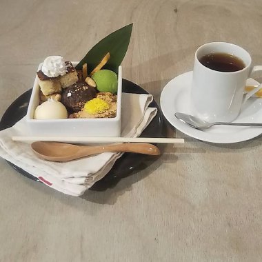 Dondurmalı çikolatalı kek ve tahta bir masada bir fincan kahve.