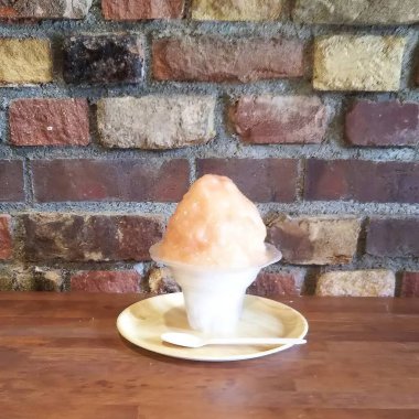 Tahta bir masada kaşıkla bir fincan dondurma.