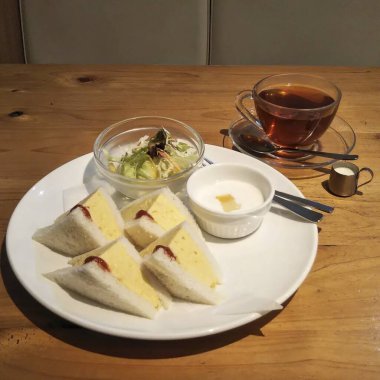 Bir fincan çay, bir kaşık ve bir fincan kahve, ahşap bir masada..