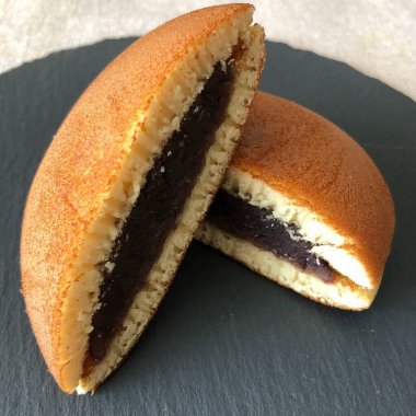 chocolate donut with icing sugar on a white background