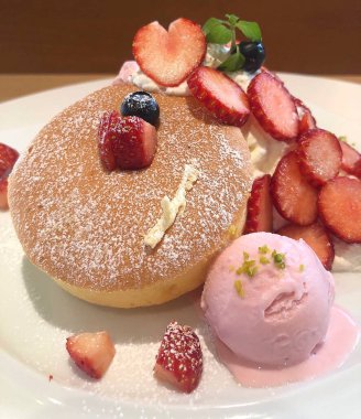 Çilekli ve vanilyalı dondurmaları tabağa koy.