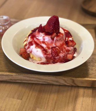 Çilekli pasta ve ahşap tabakta krem şanti.