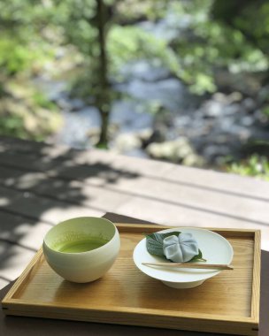 Bir fincan çay ve ahşap bir masada yeşil çay.