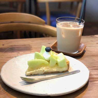 Bir parça elma ve bir fincan çayla birlikte bir kek.