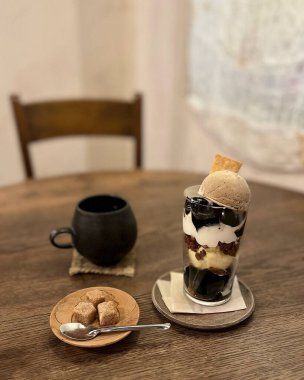 Waffle külahında dondurma ve tahta arka planda bir fincan kahve.