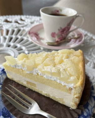 Bir parça ev yapımı limonlu pasta ve beyaz tabakta bir fincan kahve.