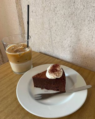 Bir fincan sıcak kahve, bir parça kek ve bir kaşık.