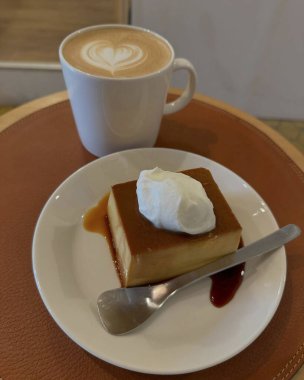 Krem şantili çikolatalı kek ve ahşap zemin üzerinde kahve.