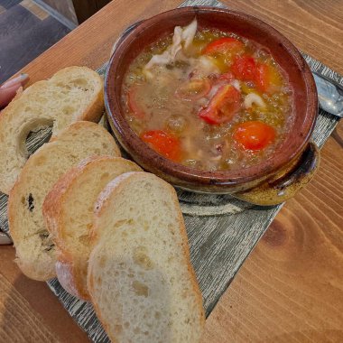 Tavuk etli çorba ve ahşap arka planda sebze.