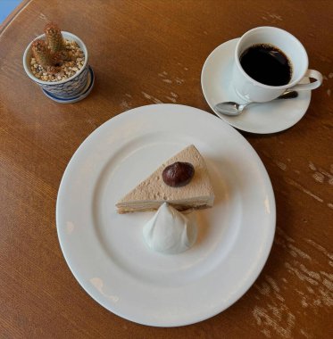 Bir fincan sade kahve ve tabakta kek.