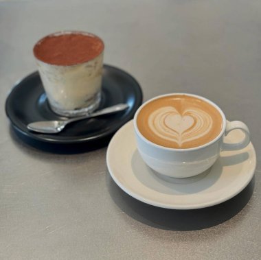 Fincanla kahveyi kaşıkla masaya koy.