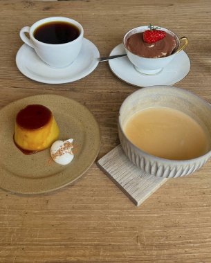 Bir fincan kahve, kremalı kek ve ahşap bir masada bir fincan kahve.