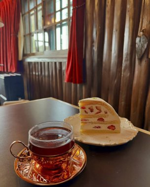 Masada limon ve kek ile bir fincan çay.