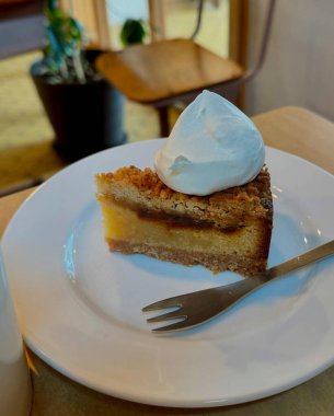 Krem şantili lezzetli bir parça kek ve bir fincan çay.