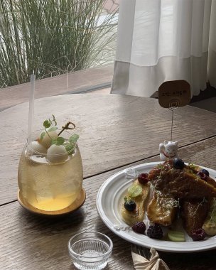 Tahta bir masada bir bardak çay ve bir bardak süt.