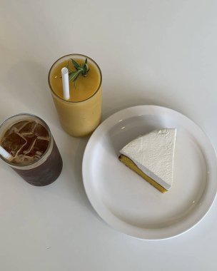 Beyaz bir tabakta bir bardak süt ve bir bardak kapuçino.