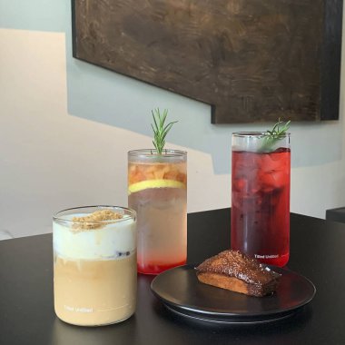 Tahta bir masada bir bardak çay ve bir bardak süt.