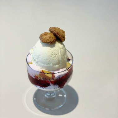 Krem şantili ve kaşıklı bir bardakta dondurma