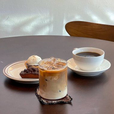 Tahta bir masada bir fincan kahve ve kek.