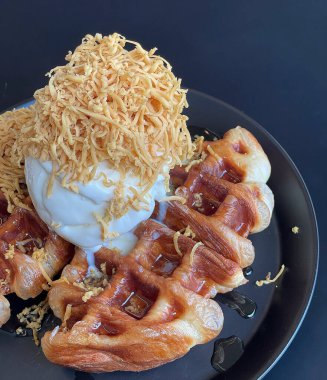 Kızarmış pirinç ve çıtır waffle. Lokantada siyah masada yumurta.
