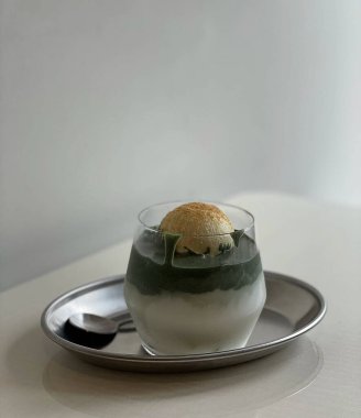 Yeşil arka planı olan bir bardak sütü kapat.