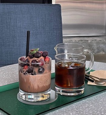 Masada buzlu ve dutlu bir bardak kahve.