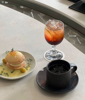 Lezzetli bir tatlıya yakın plan bir fincan kahve ve beyaz bir masada beyaz bir kaşık.