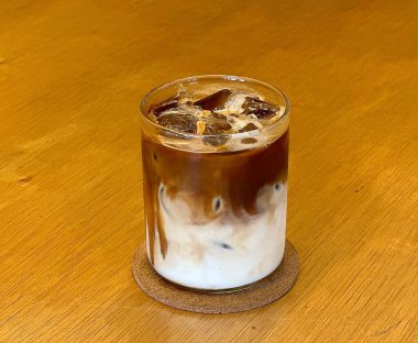 Sütlü buzlu kahve ve ahşap arka planda buz