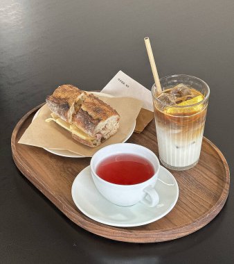 Bir bardak çay ve ahşap bir masada bir fincan kahve.