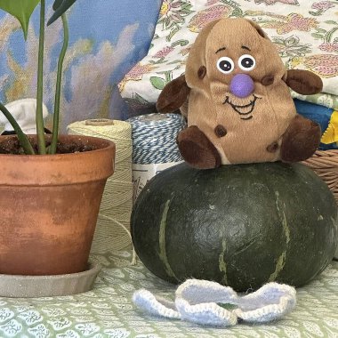 Oyuncak bir tencerede oyuncak ayı ve balkabağının dikey görüntüsü.