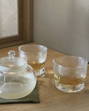 Çay fincanı ve çaydanlık ahşap masada.