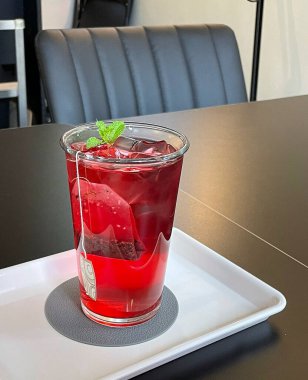 Tahta bir masada, bardakta kırmızı şarap..