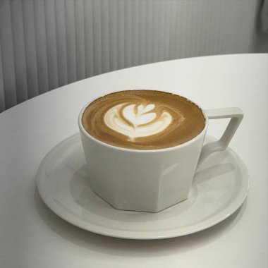 Masada beyaz bir fincan kapuçino ile sıcak çikolata.