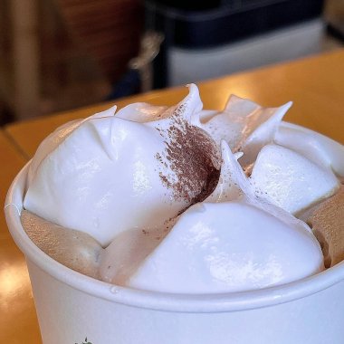 Çikolatalı kahve fincanı ve ahşap arka planda krema.