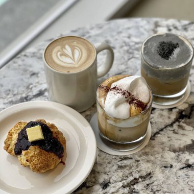 Lezzetli kurabiyeli bir fincan kahve ve beyaz bir masada bir kaşık.