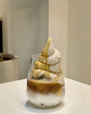 Bir bardak dondurma ve beyaz arka planda bir fincan kahve.