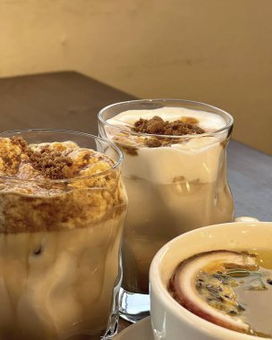 Bardakta buzlu çay, bir kaşık ve bir bardak süt.