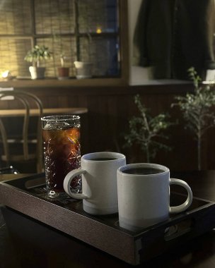 Tahta masada bir fincan kahve ve bir bardak viski.