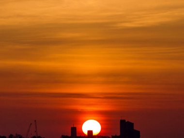 Gün batımında bir şehrin silueti.