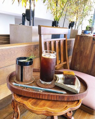 Kahve fincanı ve çay, ahşap masanın üstünde.