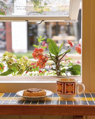 Kahve dükkanında kahve fincanı ve çiçek.