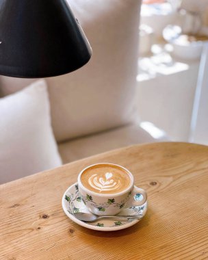 Kahve fincanı ve beyaz çiçekli kapuçino.