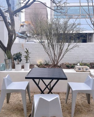 Boş ahşap masa ve bahçede sandalyeler.