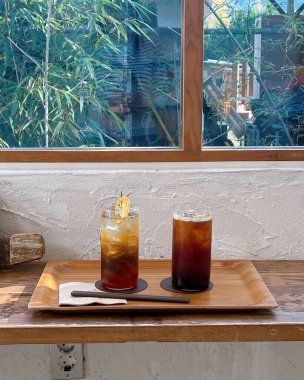 Ahşap masada bir bardak buzlu kahve.