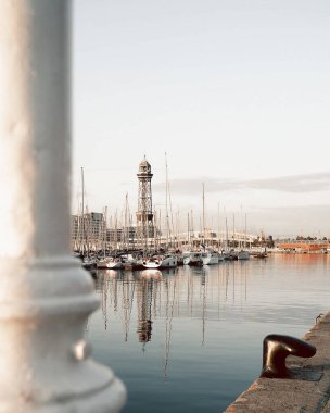 Güneşli bir günde beyaz bir deniz fenerinin dikey görüntüsü.