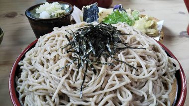 Bir kase soya soslu erişte ve yemek çubuğu.