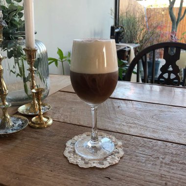 Tahta bir masada, fincanda sıcak çikolata.